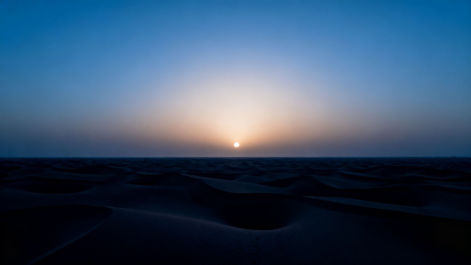 Die Wüste bei Dubai kurz vor Sonnenaufgang, mit flachem Horizont